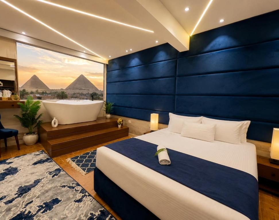 Guest room with a freestanding bath and window looking out to the pyramids at sunset