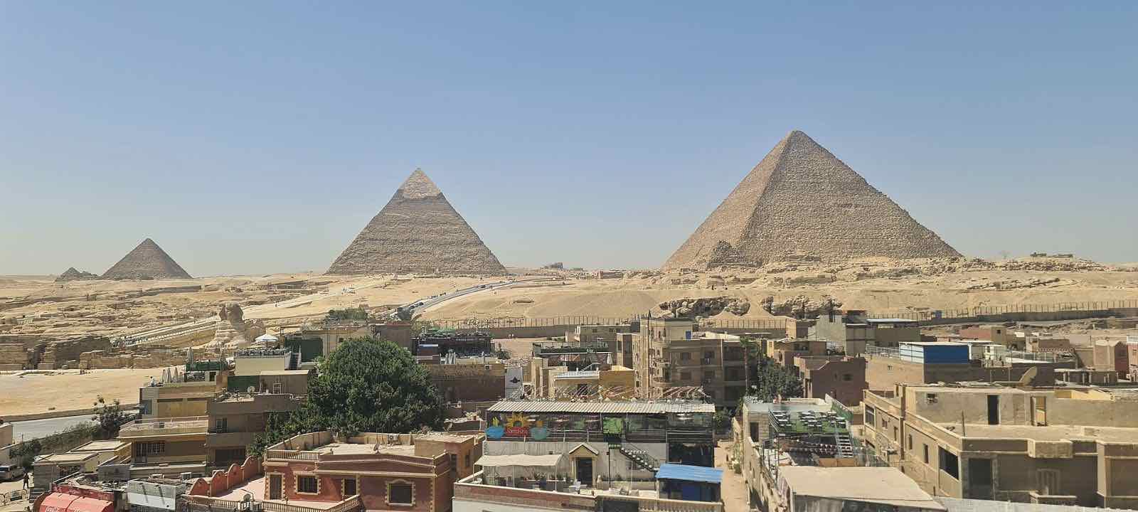 The pyramids of Giza rising beyond the rooftops of the town