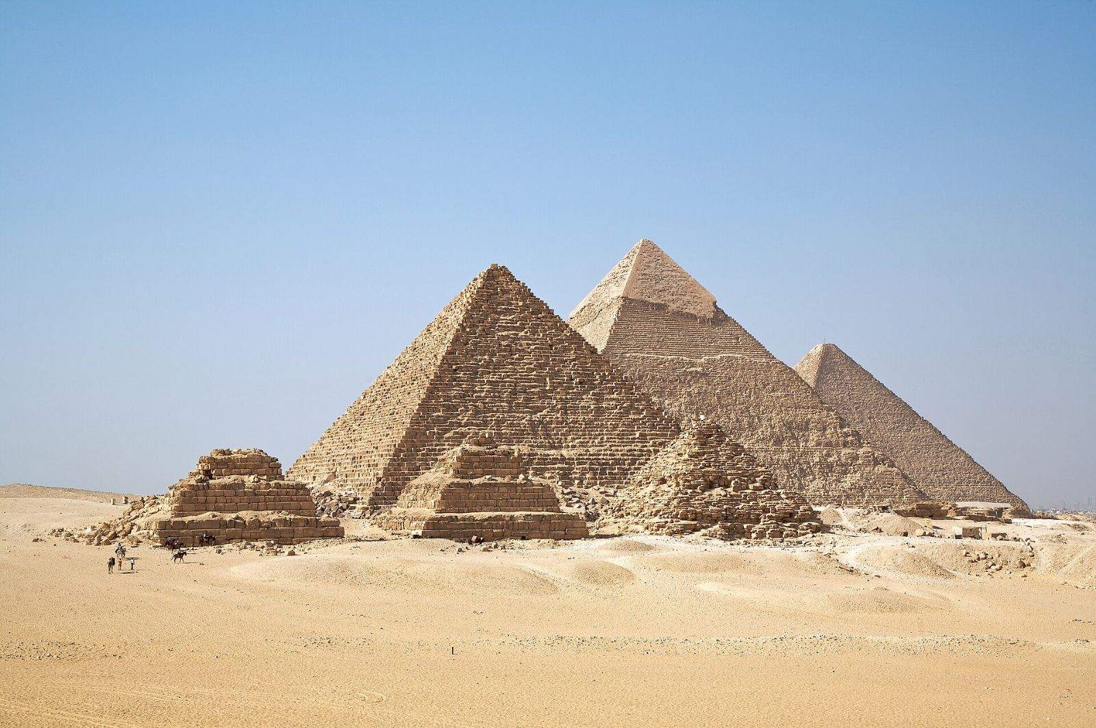 The three pyramids of Giza and the smaller queens' pyramids under a clear sky