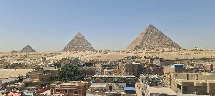 The pyramids of Giza rising beyond the rooftops of the town