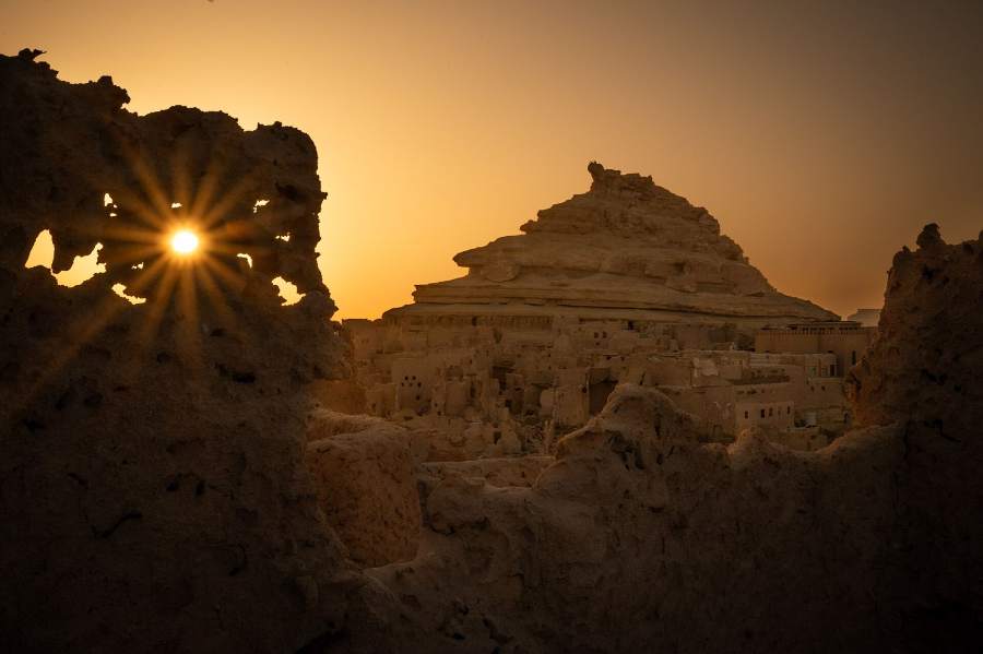 The mud-brick ruins of Shali in Siwa, backlit by the sun