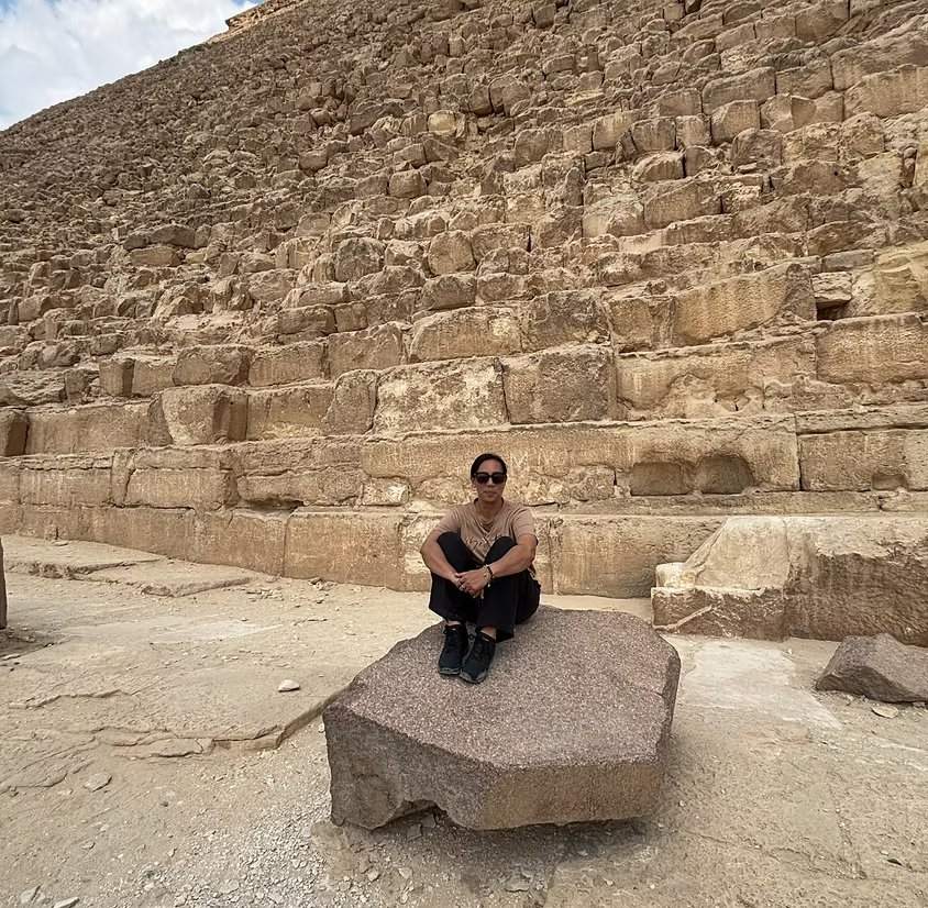 Teane 'Tee' Kenny sitting on a granite block at the base of the Great Pyramid of Giza